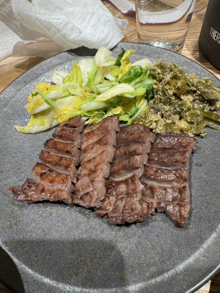 Thick-Cut Charcoal-Grilled Beef Tongue served with fresh salad and traditional Japanese side dishes at Kisuke Yaesu North Exit, Tokyo Station. A famous Sendai specialty known for its tender texture and rich charcoal-grilled flavor.