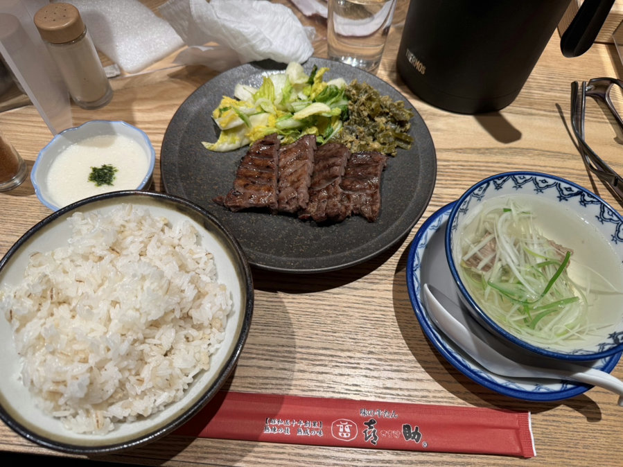 Thick-Cut Charcoal-Grilled Beef Tongue Set Meal at Kisuke Yaesu North Exit, Tokyo Station. A famous Sendai specialty served with barley rice, oxtail soup, yam, pickled vegetables, and fresh salad for a complete Japanese dining experience.