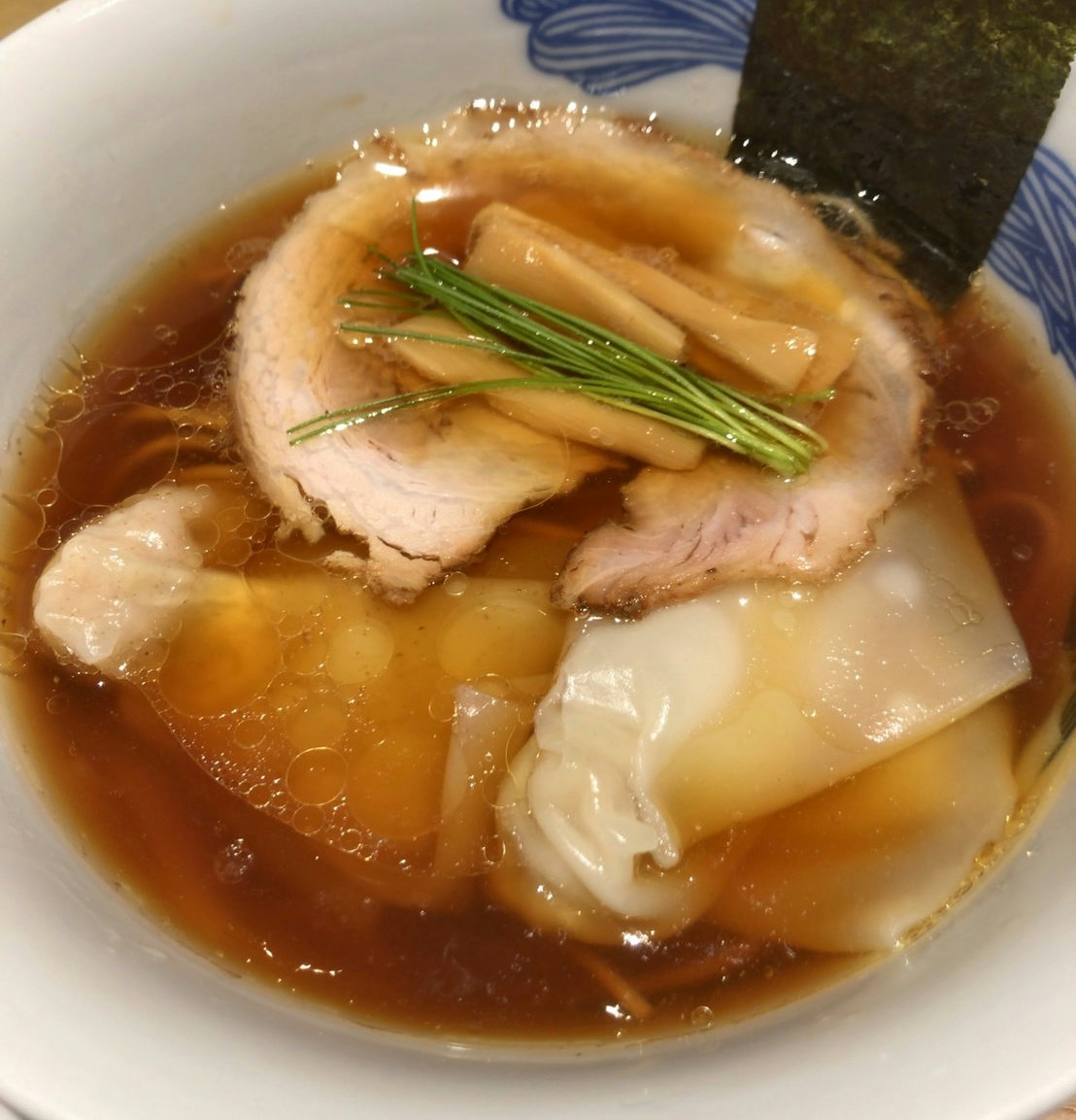 A bowl of clear shoyu ramen served at NIPPON RAMEN RIN TOKYO inside Tokyo Station, made with Japanese chicken and soy sauce.