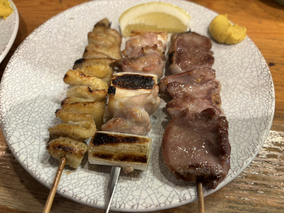 ALT: Kawa, negima and tan skewers at Mitsumasa in Shimbashi, Tokyo, served with lemon and mustard.