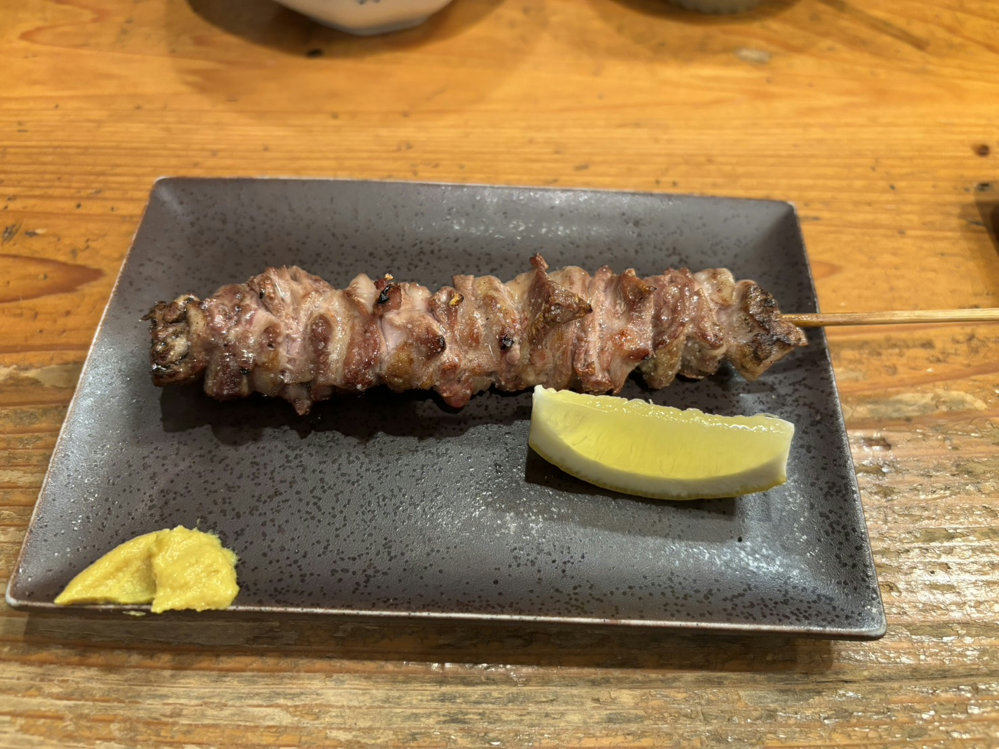 ALT: Grilled hatsumoto skewer at Mitsumasa in Shimbashi, Tokyo, served with lemon and mustard.